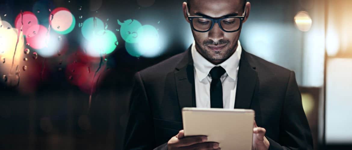 homem negro com perfil executivo interagindo com um ipad