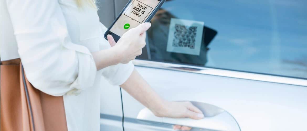 Imagem de uma mulher tentando abrir a porta de um carro realizando a leitura de um QR Code