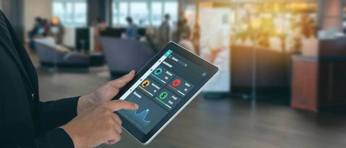 Imagem conceito do uso de machine learning e inteligência artificial em uma loja. Pessoa segura um tablet, que contém dados que podem ajudar na tomada de decisão