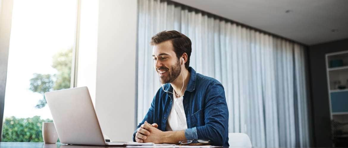 Homem olhando para a tela de um computador durante trabalho home office