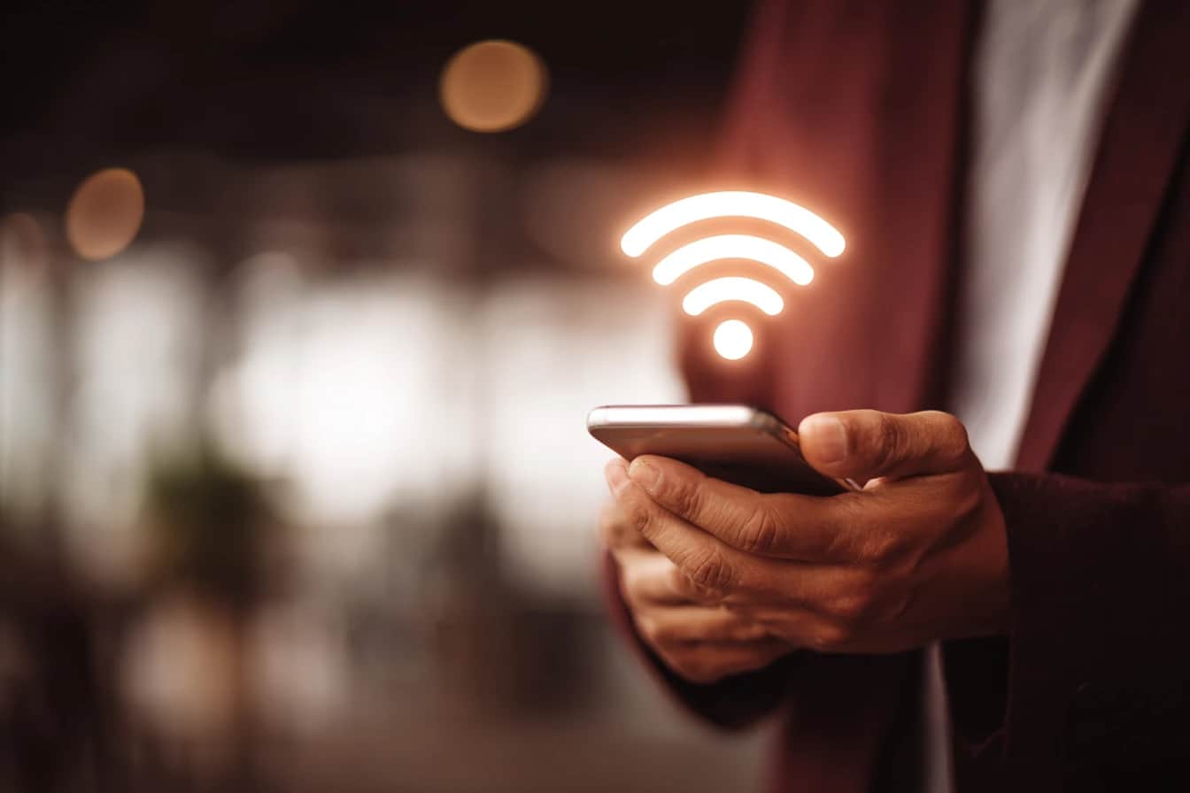 Pessoa usando smartphone para acessar rede Wi-Fi, representando inovação do Serpro na compra de banda larga via pregão eletrônico.