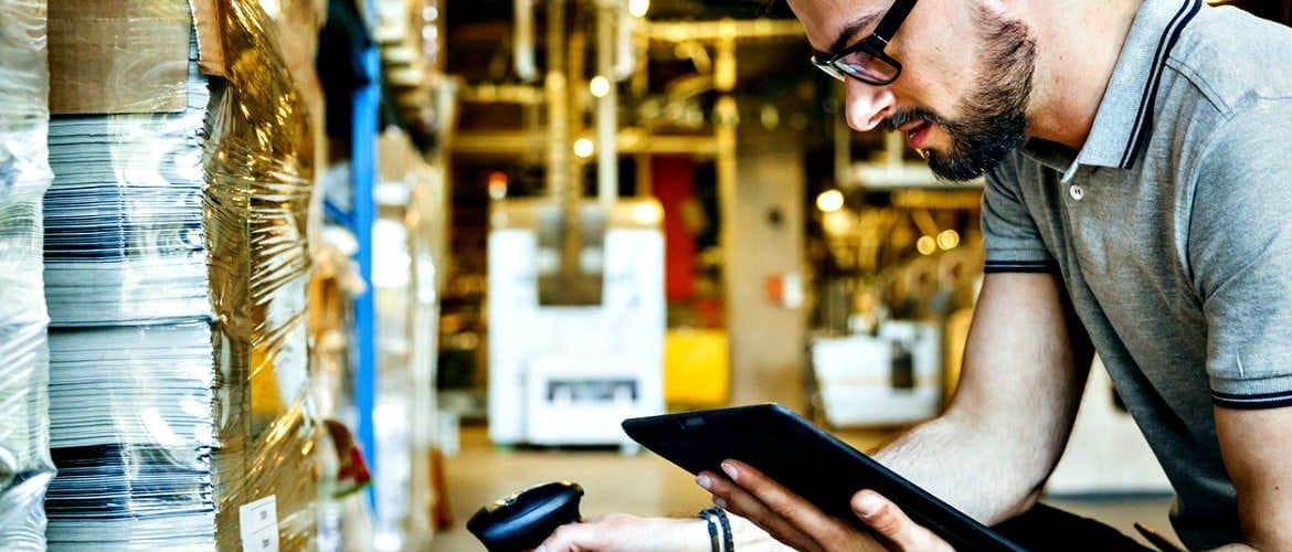 Homem com tablet e leitor RFID é um exemplo do impacto da IoT e do 5G na logística