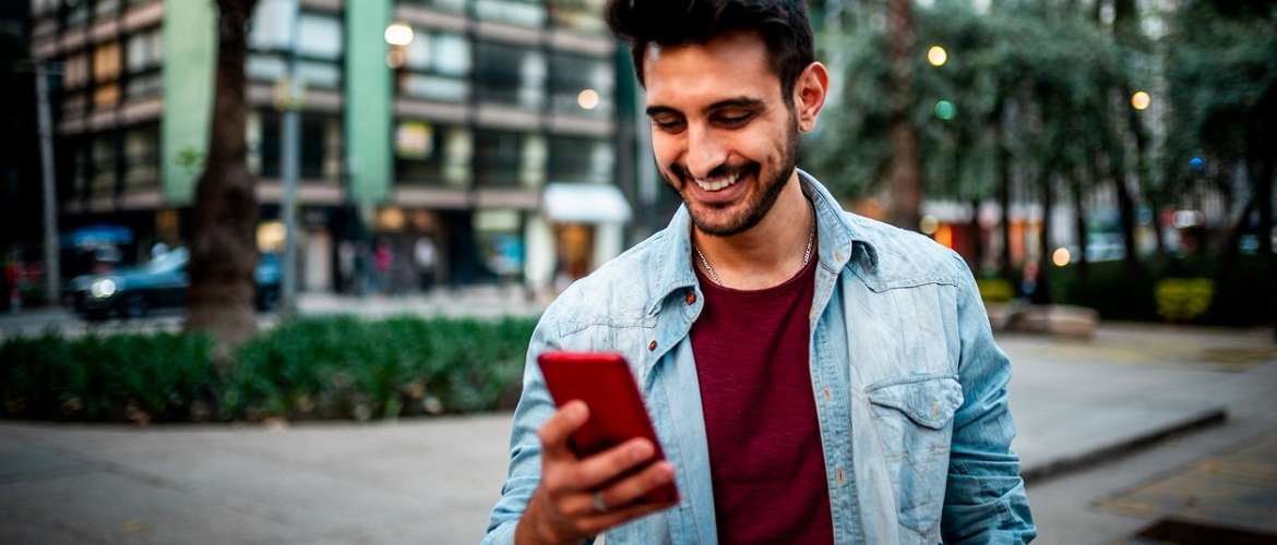 Homem olha para um telefone celular em uma interação de consumo