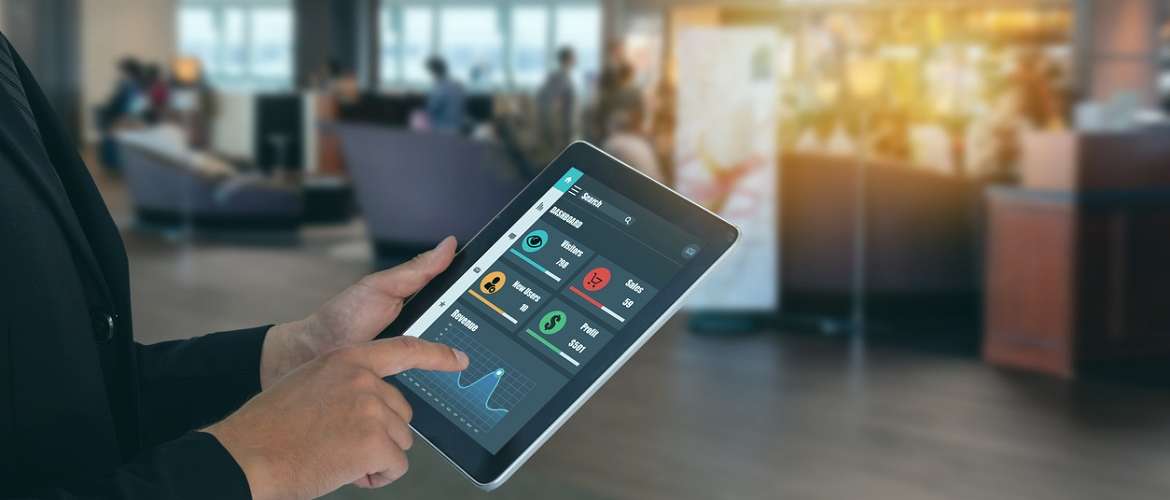 Imagem conceito do uso de machine learning e inteligência artificial em uma loja. Pessoa segura um tablet, que contém dados que podem ajudar na tomada de decisão