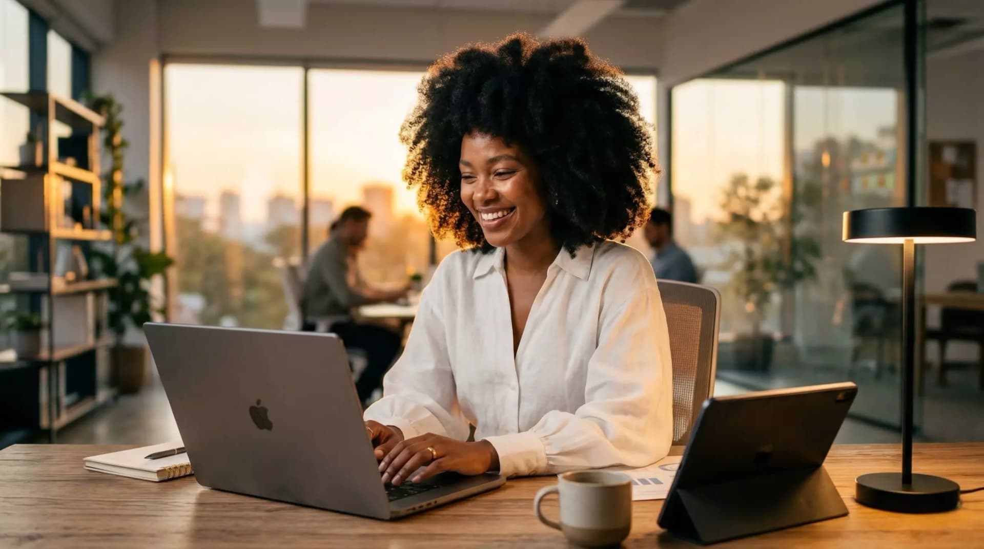Mulher sorridente em escritório moderno, usando notebook e explorando a diferença entre dados e informação de forma prática e eficiente.