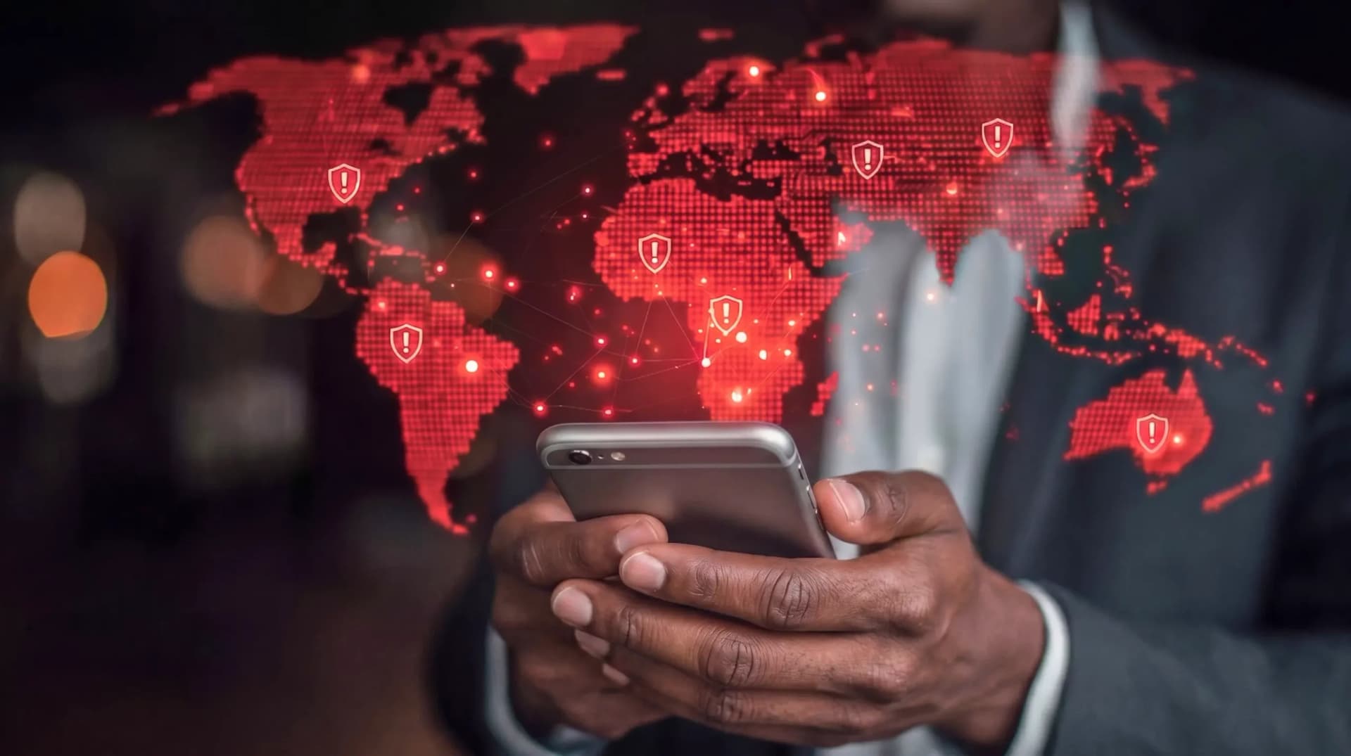 Homem de terno usando smartphone com um mapa mundial digital em tons de vermelho ao fundo, representando riscos digitais e inteligência artificial nas empresas