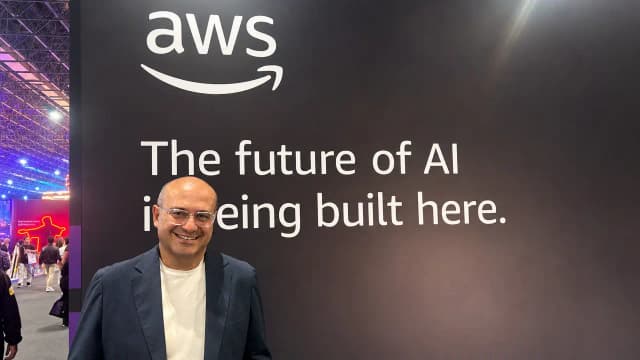 Cléber Morais, diretor-geral da AWS no Brasil em frente ao painel da empresa no evento Web Summit Rio 2026