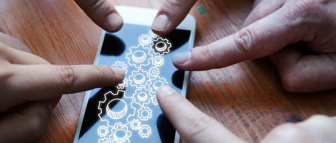 Pessoas apontando o dedo para a tela de um smartphone para exemplificar a transformação digital