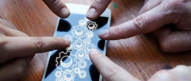 Pessoas apontando o dedo para a tela de um smartphone para exemplificar a transformação digital
