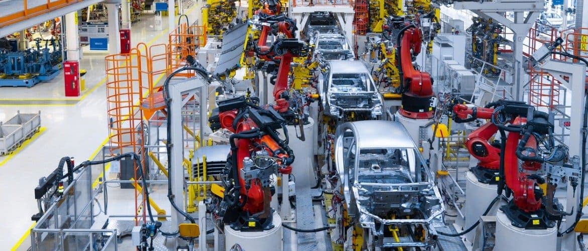 Linha de produção automotiva com robôs auxiliando na produção de veículos