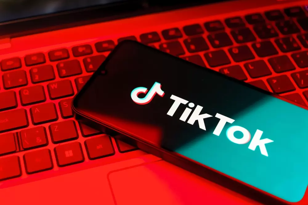 TikTok investe R$ 50 bilhões em data center no CE. Na foto um smartphone com o logotipo do TikTok sobre um teclado iluminado em tons de vermelho.