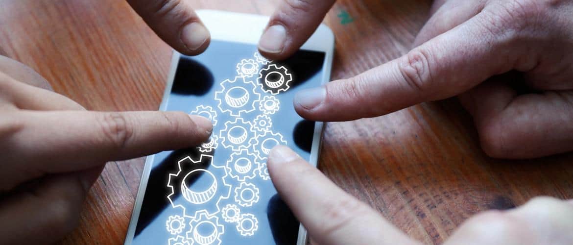 Pessoas apontando o dedo para a tela de um smartphone para exemplificar a transformação digital