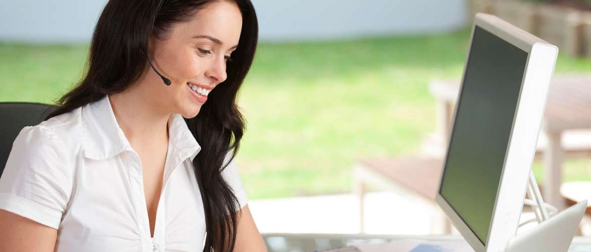 Mulher usa um telefone com um headset em um atendimento realizado em casa
