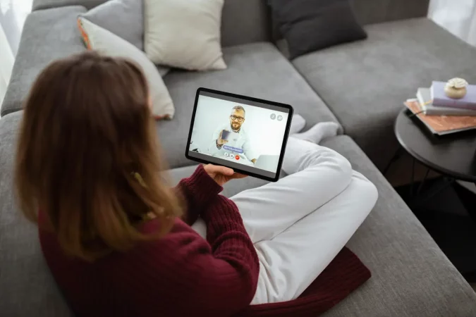Pessoa assistindo uma consulta médica por telemedicina pelo tablet, promovendo conceitos de saúde 5.0 e tecnologia na medicina moderna.