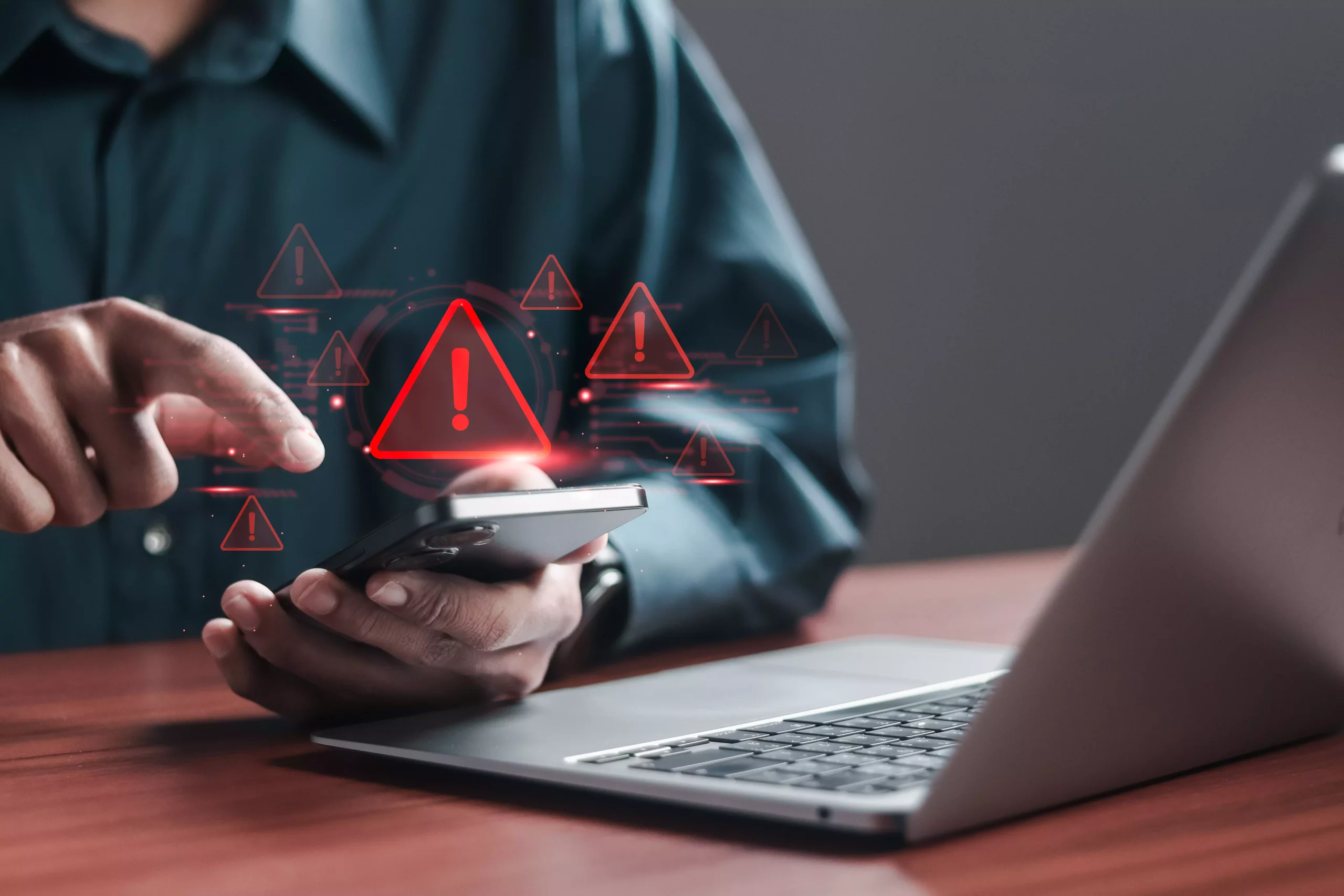 Pessoa usando celular com alertas de segurança e aviso de risco digital, simbolizando ameaças cibernéticas e segurança online.