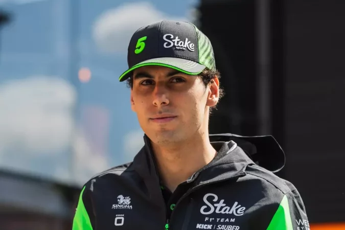 Piloto de corridas usando uniforme com a palavra-chave 'stake esportes', destacando uma pessoa com capacete e roupas de corrida de alta performance.